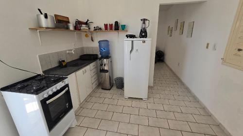 a kitchen with a stove and a refrigerator at Apartamento Guriri Verão in São Mateus