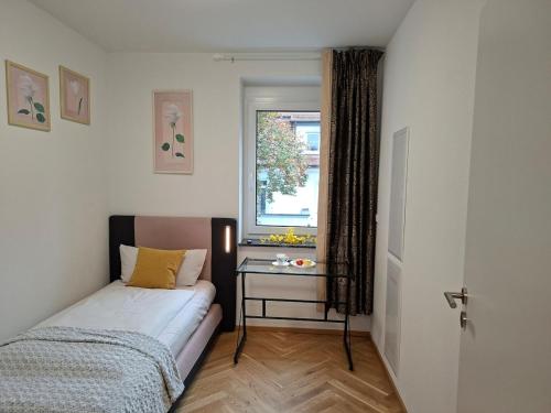 a small bedroom with a bed and a window at Ravensburg City Apartment in Ravensburg