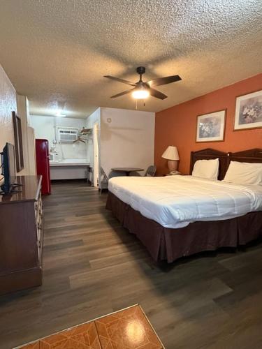 a hotel room with a bed and a ceiling fan at Hico Hills Inn in Hico