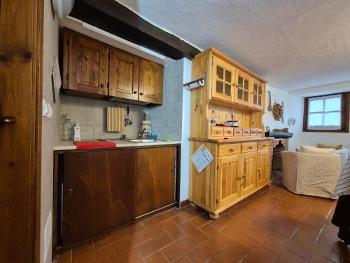Una cocina con gabinetes de madera y encimera. en Casa Camilla, Casa Vacanze sulle colline di Lerma, en Lerma