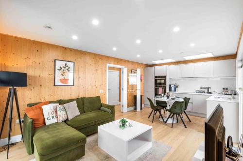 a living room with a green couch and a table at Green Mews 1 with Free Parking By My Getaways in Brighton & Hove