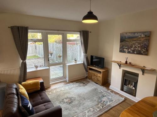 a living room with a couch and a fireplace at Rosedale House Your home away to home in Cottingham