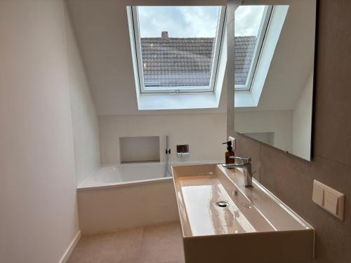 a bathroom with a sink and a bath tub at Premium Landhauswohnung in Neuenkirchen