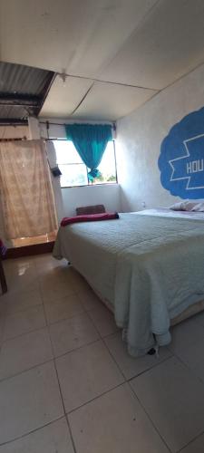 Un dormitorio con una cama grande con ventana. en House Zope, en Panajachel