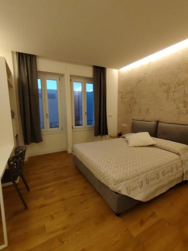 ein Schlafzimmer mit einem Bett in einem Zimmer mit Fenstern in der Unterkunft guest house museum in Sassari