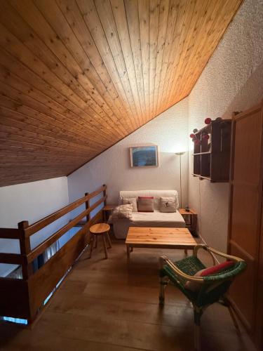 Un dormitorio con una cama y un techo de madera. en beau duplex marmotiere, en Risoul