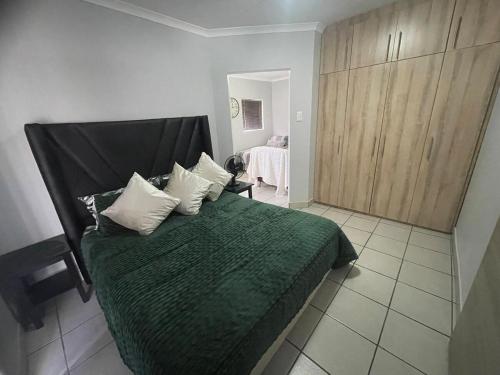 a bedroom with a bed with a green blanket and pillows at The Gather Inn Bethlehem in Bethlehem