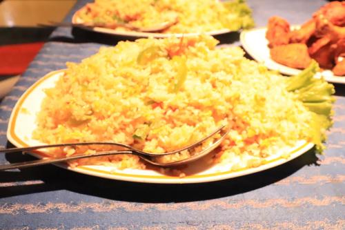 ein Teller mit Essen und Reis auf einem Tisch in der Unterkunft Sea Shell Hotel - Sales & Booking Office in Bāiljuri