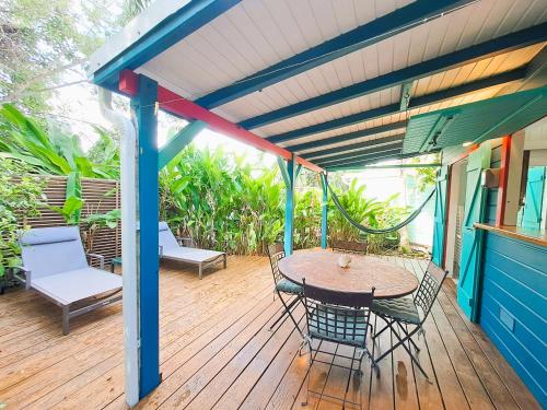a patio with a table and chairs on a deck at Secteur prisé, bungalow Corail, Résidence CASA BOUBOU in Sainte-Anne