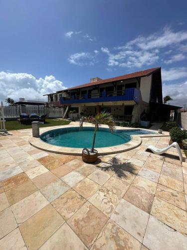 a building with a swimming pool with a palm tree in it at Recanto do Amor in Cascavel
