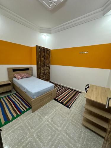 a bedroom with a bed and colorful walls and carpet at Dar Ben Othman in Tozeur