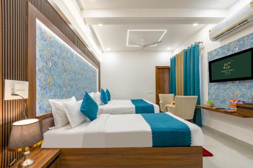 a hotel room with a bed and a flat screen tv at Honeyveils Palace Hotel - Behind Indian Expo Mart in Greater Noida