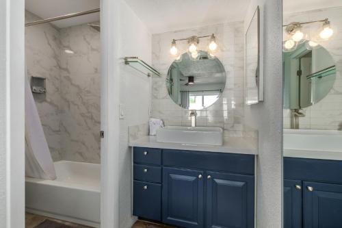 une salle de bain avec un lavabo, une baignoire et un miroir dans l'établissement Blue Abode - Old Town Scottsdale - Pool &BBQ Grill, à Scottsdale