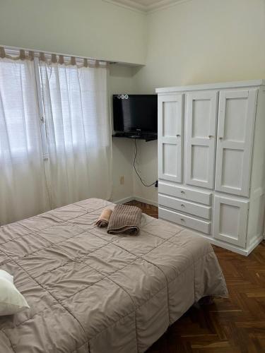 a bedroom with a large bed and a dresser at Pasala Lindo in Tandil