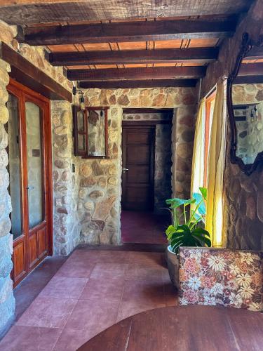 an entrance to a stone building with a wooden door at Casa de piedra con jardin y pileta - privada in Los Hornillos