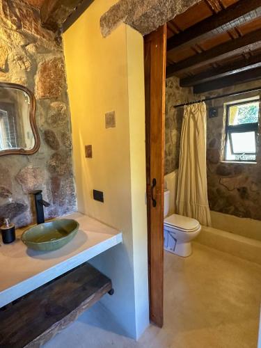 a bathroom with a sink and a toilet at Casa de piedra con jardin y pileta - privada in Los Hornillos