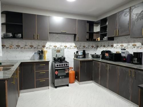 a kitchen with wooden cabinets and a stove top oven at Emraan Residence in Nakuru