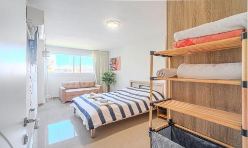 a bedroom with a bunk bed and a couch at דירת הפרימיום - 5 דקות נסיעה מהים in Ashqelon