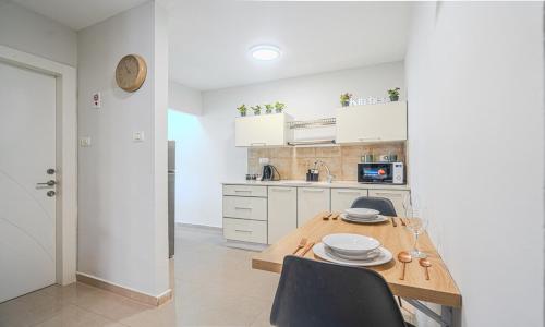a kitchen with a wooden table with plates on it at דירת הפרימיום - 5 דקות נסיעה מהים in Ashqelon