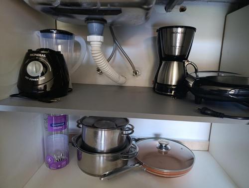 a kitchen shelf with pots and pans and a blender at Two-bedroom apartment CDE - Area 4 - Close to everything in Ciudad del Este