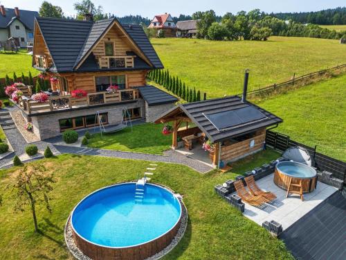 ノヴィ・タルクにあるVilla in Nowy Targ with Mountain Views & Poolのプール付きのログハウスの航空写真