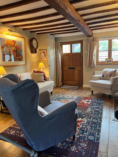 a living room with couches and a rug at Charming cottage in Urchfont