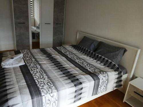 łóżko z czarno-białą kołdrą w pokoju w obiekcie Double BO Apartment w mieście Skopje