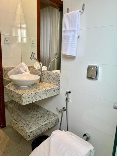 a bathroom with a sink and a mirror at Gran Vale Hotel in Guanhães