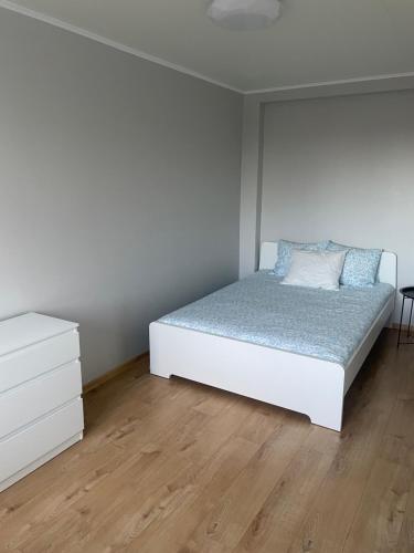 a white bedroom with a bed and a dresser at Apartment in the city centre of Tapa in Tapa