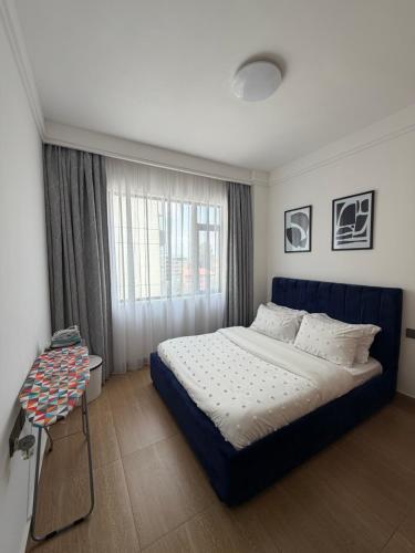 a bedroom with a large bed and a window at Tranquil Haven by the UN Ruaka 1BR with Pool &Gym in Ruaka