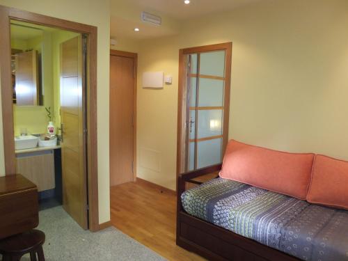 バイヨーナにあるApartamentos Ababides Playaのベッドルーム1室(ベッド1台付)、バスルーム(鏡付)
