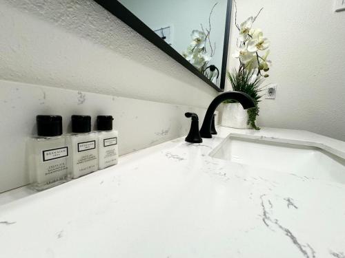 a bathroom sink with a faucet in front of a mirror at The Loose Moose Book The 11-unit Mountain Lodge! in Grand Lake