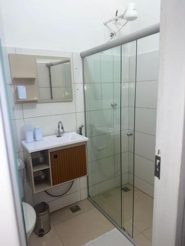a bathroom with a glass shower and a sink at Studio apartment - Bom Retiro - S05 in Ipatinga