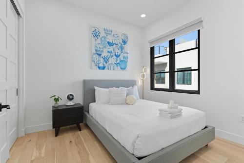 a white bedroom with a bed and a window at Papago Townhouse-Rooftop Deck-Old Town in Scottsdale
