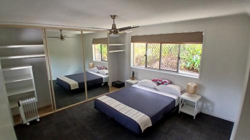 une chambre avec deux lits et un grand miroir dans l'établissement Peaceful Country Home Between Brisbane & GC, à Wolfdene