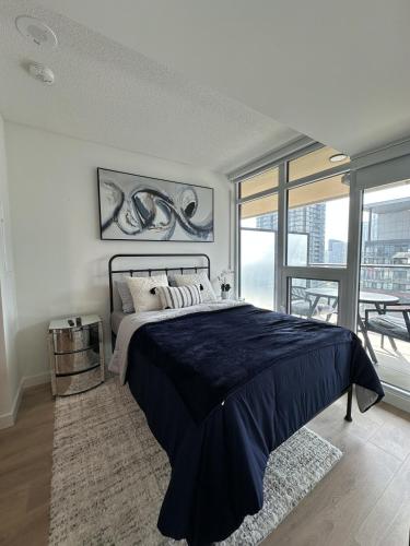 a bedroom with a large bed and a large window at Entire Luxe Condo in Downtown Toronto in Toronto