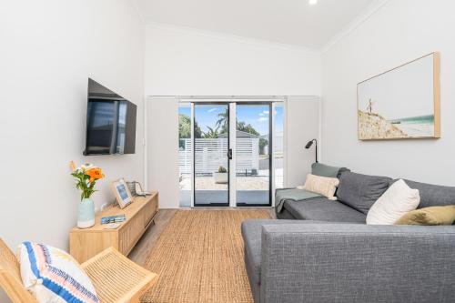 a living room with a couch and a table at 'Short Break' - Luxurious Coastal Retreat with Pool and BBQ in Urangan