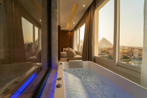 カイロにあるKemet Pyramids View Hotelのピラミッドを望むバスルーム(バスタブ付)