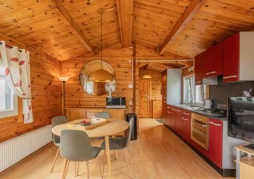 a kitchen with a table and chairs in a room at Chaletparc Krabbenkreek Zeeland - Chalet 130 in Sint Annaland