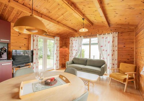 a living room with a couch and a table at Chaletparc Krabbenkreek Zeeland - Chalet 130 in Sint Annaland