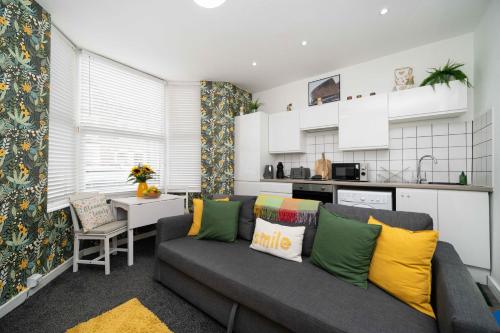 ein Wohnzimmer mit Couch und Küche in der Unterkunft Cosy City Stay - Heart of Cardiff in Cardiff
