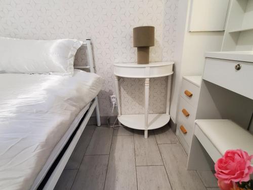 a small bedroom with a bed and a table at Le Refuge Nature à 20 min de Paris et d'Orly via RER Juvisy in Draveil