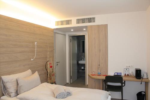 a bedroom with a bed and a desk and a table at Locanda Marco in Bellinzona