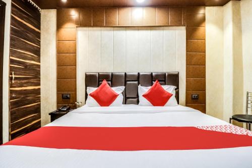 a bedroom with a large bed with red pillows at Hotel O JPS Galaxy Hotel in New Delhi