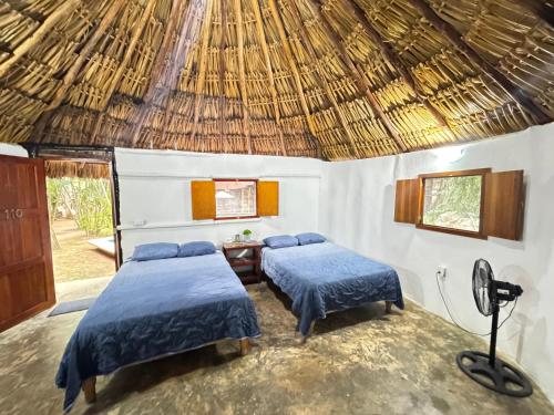 Felipe Carrillo PuertoにあるHotel Bambusの藁葺き屋根の部屋 ベッド2台
