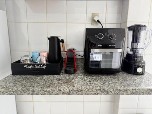a kitchen counter with a coffee maker and a blender at Kitnet - Centro - Ipatinga in Ipatinga