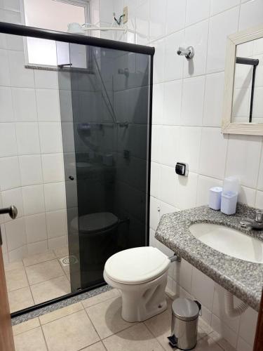 a bathroom with a shower and a toilet and a sink at Kitnet - Centro - Ipatinga in Ipatinga