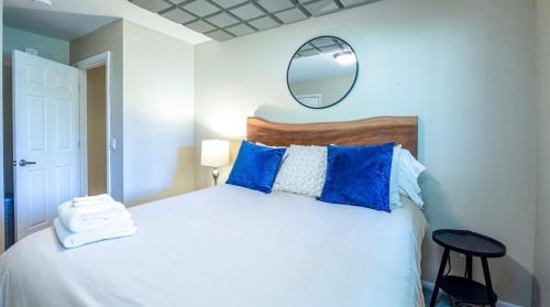 a bedroom with a bed with blue pillows and a mirror at Baby Bella- w/ concierge laundry service in Corvallis