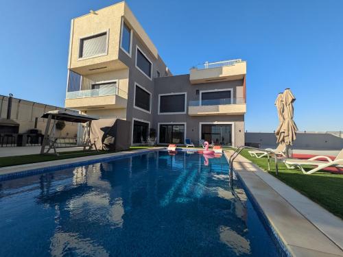 a swimming pool in front of a building at Noorhan Private Luxury Layover Villa - 10 Minutes to Airport in Amman