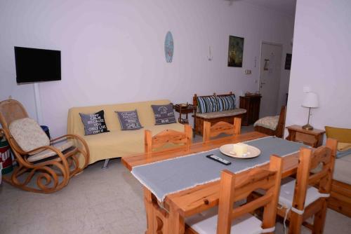 ルートラキにあるLucy's comfy apt in town centre by the seaのソファとテーブルと椅子のあるリビングルーム